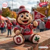 Front view of an Ohio State Buckeyes crochet mascot plush doll holding a small pennant and a football.
