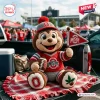 Front view of an Ohio State Buckeyes crochet mascot plush doll sitting on a plaid blanket in a truck bed.