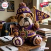 Front view of an Omega Psi Phi bulldog crochet plush toy wearing a purple hat and jersey holding a triangular pennant.
