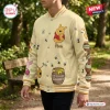 Side view of a person wearing a cream baseball jacket with Winnie the Pooh and honey pot illustrations.