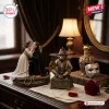 Detailed figures of a couple embracing alongside a toy monkey, ornate bottle, and mask on a desk with sheet music.