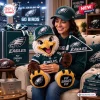Woman holding a Philadelphia Eagles crocheted plush doll wearing a hat and jersey while sitting in a living room.