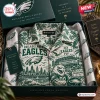 Top view of a folded Philadelphia Eagles Hawaiian shirt featuring the stadium, city skyline, and eagle mascot graphics.