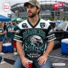Man wearing a Philadelphia Eagles Birds Unite t-shirt with eagle and stadium graphic in a stadium parking lot setting.