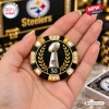 Close-up of a hand holding a black and gold poker chip with a trophy and the number 50 as part of a poker set.