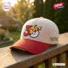 Front view of the Pokémon 30th Anniversary Red Beige Baseball Hat resting on a wooden railing outdoors.