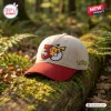 Front view of the Pokémon 30th Anniversary Red Beige Baseball Hat resting on a mossy log.