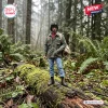 Full body shot of a Rambo First Blood 45th Anniversary Hot Toys Figure standing on a mossy log in a forest setting.