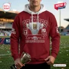 Front view of a person wearing a maroon hoodie with Redcliffe Dolphins 2026 Hostplus Cup Premiers graphics and holding a trophy.
