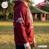 Side view of a person wearing a maroon Redcliffe Dolphins hoodie with sleeve graphics.