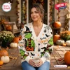 Front view of a woman wearing a Resting Grinch Face Halloween knitted cardigan featuring festive pumpkin and spider motifs.