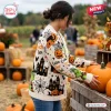 Side view of a person wearing a cream Halloween knitted cardigan with Grinch, pumpkin, and haunted house patterns.