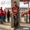 Man wearing a red distressed T-shirt with 49ers graphics, posing at a stadium entrance.