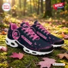 Side view of San Francisco 49ers x Breast Cancer Awareness Air Max Plus Sneakers resting on autumn leaves.