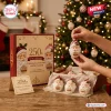 Santa Claus 250th Anniversary Advent Calendar box and hand holding a small blown glass Santa ornament by a lit tree.