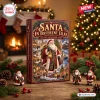 Front view of Santa In Different Eras Advent Calendar 2026 box displayed on a wooden table with figurines and a lit fireplace.