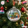 Close-up view of a glass Christmas ornament containing a miniature van and group of characters in a snowy scene.