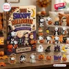 Front view of a 2026 Snoopy Halloween advent calendar box with various holiday character ornaments arranged on a table.