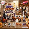 Front view of a 2026 Snoopy Halloween advent calendar box with hanging character ornaments on a wooden table.