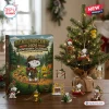 Front view of a 2026 Beagle Scout advent calendar box next to a miniature Christmas tree with themed hanging ornaments.