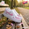 Side view of Snoopy Breast Cancer Awareness Air Force 1 Sneaker on a park bench.