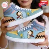 Close-up of hands holding two light blue high top sneakers featuring a cartoon pilot dog and yellow bird print.