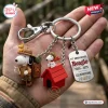 Hand holding a keychain featuring a scout character, red doghouse, and a 75th anniversary tag.