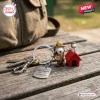 Close up of a Snoopy red doghouse and beagle 75th anniversary keychain resting on a weathered wooden surface.