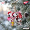 Close-up view of Snoopy x Coca-Cola Breast Cancer Awareness Advent Calendar hanging from a pine tree branch.