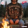 Front view of the Somewhere Western Mountain Skeleton Knit Sweater worn by a person sitting by a campfire.