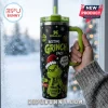 Stanley The Grinch Resting Face 40oz Tumbler with a green handle, black exterior, holiday ornaments, and text design.