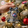 Close-up of a hand holding a blue bell ornament featuring a lightsaber duel scene on a Christmas tree.