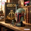 Front view of the Boba Fett Helmet Brick Set next to its collector box on a wooden desk.