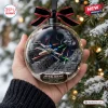 Close-up of a hand holding a clear Christmas ornament featuring a space battle diorama with fighter ships and a station.