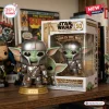 Front view of Grogu in Mandalorian armor vinyl figure with its branded display box on a wooden shelf.