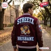 Rear view of a man wearing a maroon StreetX Brisbane Lions 2026 AFL Premiers varsity jacket outdoors.
