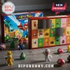 Super Mario Rabbids Kingdom Battle Advent Calendar with miniature figures of Mario, Rabbids, and power-up mushrooms on wood.
