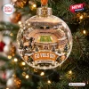 Close-up of a clear globe Christmas ornament featuring a football stadium miniature and a hound dog figurine.