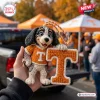 Close-up of a Tennessee Volunteers crochet mascot car ornament being held outdoors near tailgate tents.