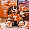 Front view of a crocheted Tennessee Volunteers mascot doll holding a miniature football and a pennant flag.