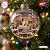 Close-up of a clear Texas A&M University 150th Anniversary Glass Christmas Ornament hanging on a lit tree.