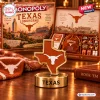 Front view of Texas Longhorns Collector Edition Monopoly board game box with gold metal state token and branded drawstring bag.