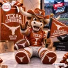 Front view of the Texas Longhorns Mascot Plush Pillow sitting with a football and team flag.