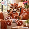 Front view of the Texas Longhorns Mascot Plush Pillow sitting on a couch with a football and flag.