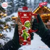 Front view of a 40oz Stanley Tumbler with holiday character graphic held in gloved hands against a snowy outdoor background.