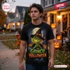 Front view of a man wearing a black shirt with a green character in a witch hat and pumpkins for a Halloween theme.