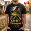Front view of a black Grinch Witch Hat Halloween shirt featuring a graphic of the character wearing a pumpkin-adorned hat.
