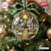 Close-up of a clear glass Christmas ornament featuring a miniature adventurer figure and a stone castle inside.