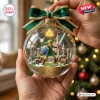Hand holding a clear sphere ornament containing a miniature fantasy hero figure with sword, shield, and castle background.