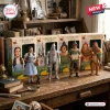 The Wizard of Oz 87th Anniversary Figure set featuring Dorothy, Tin Man, Scarecrow, and Cowardly Lion on a wooden table.